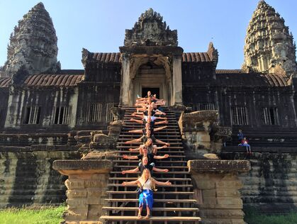 Gruppe sitter på trappen ved Angkor-tempelet